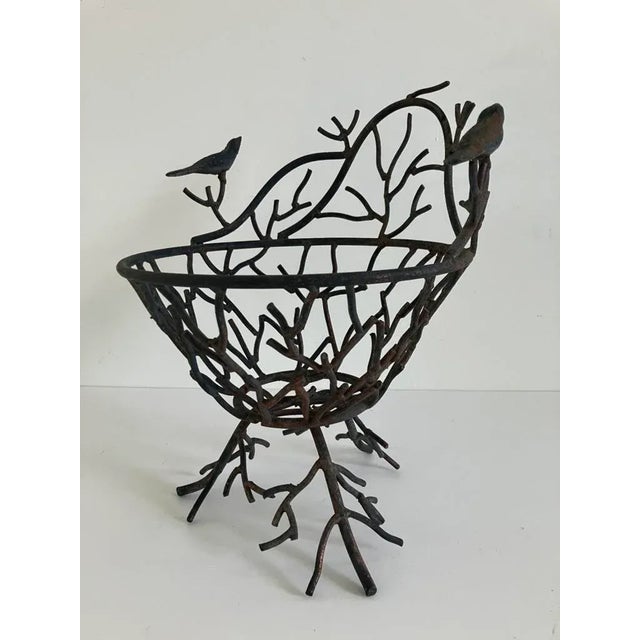 A decorative basket crafted in wrought iron with a whimsical branch-and-bird motif. Likely mid to late 20th century, this...
