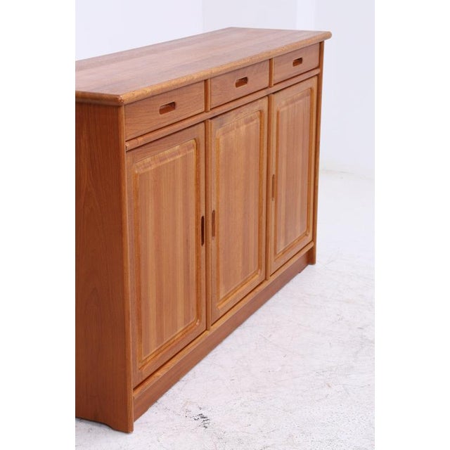 Vintage teak highboard by Dyrlund with three drawers and plenty of closed storage space. The rounded top, recessed...