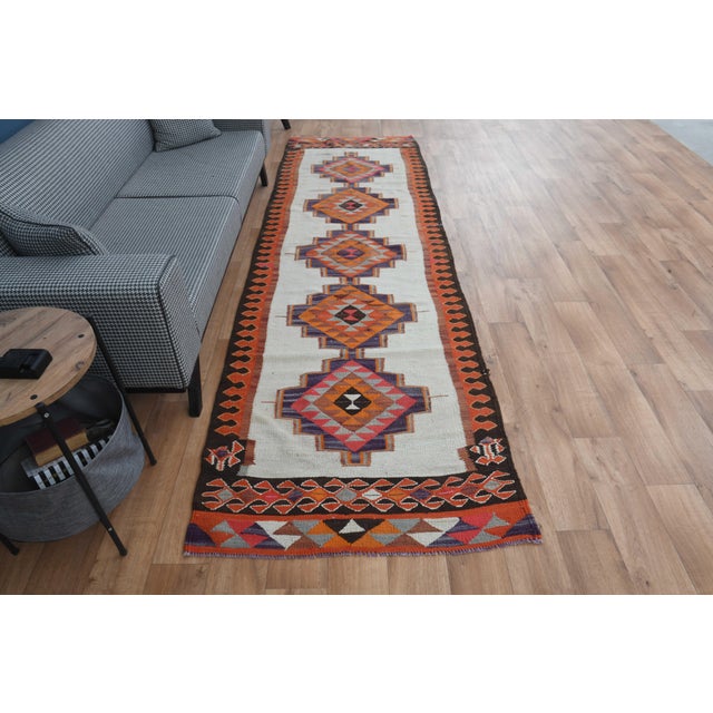 Vintage Hand-Knotted runner rug is a semi-antique vintage area rug. The '70s Eastern region of Anatolia's unique rug is...
