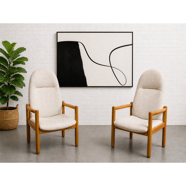 Pair of Mid Century Modern lounge chairs featuring sculptural solid oak frames and newly upholstered in a neutral white...