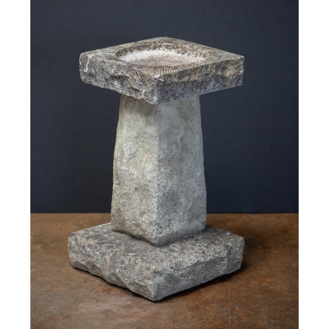 A fine English garden bird bath of composition stone, featuring a square top with round recessed bath area in the center...