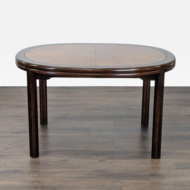 This Drexel dining table features a beautiful oval shape and a classic dark wood finish. The table is expandable, making...