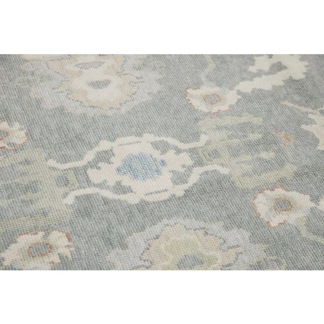 This modern Turkish Oushak rug is a stunning piece of art that has been handwoven using traditional techniques by skilled...