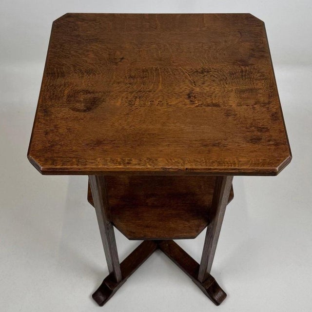 A refined early 20th-century English side table, finely crafted from oak and displaying the restrained proportions and...