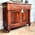 Elegant bow front cabinet featuring stunning crotch mahogany veneer, rich warm tones, and refined antique gold accents...