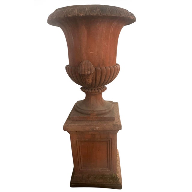 A striking vintage terracotta urn on pedestal, handcrafted in Italy and inspired by classical Neoclassical design. This...