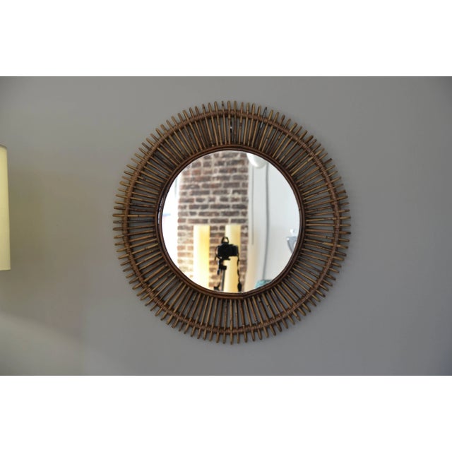 Pair of 'Oculus' round rattan mirrors by design Frères. Flat mirror inserted into an intricate rattan frame. Available Now