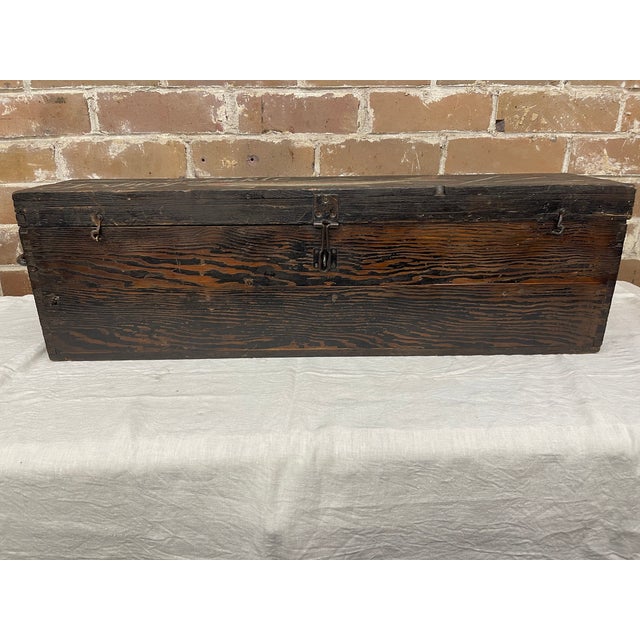 An antique wooden fishing tackle box with hand-painted decoration that includes a large fish (appears to be a bass),...