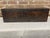 An antique wooden fishing tackle box with hand-painted decoration that includes a large fish (appears to be a bass),...