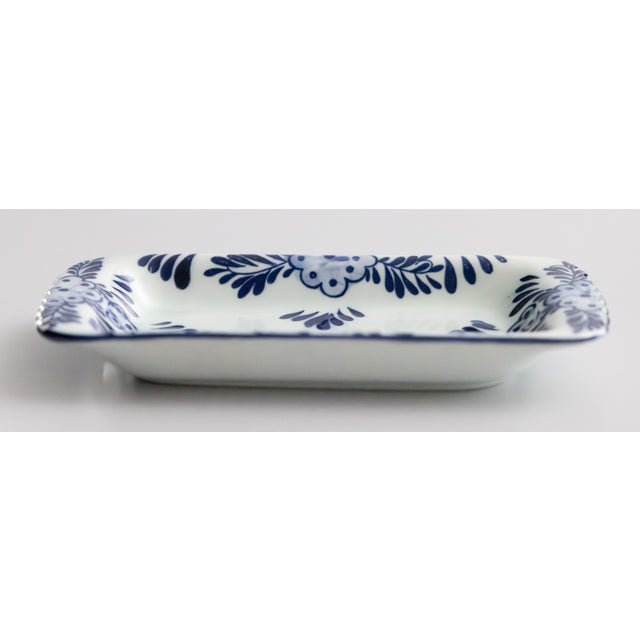A lovely vintage Dutch Delft floral blue and white jewelry tray or Vide-Poche catchall trinket dish. Maker's mark on...