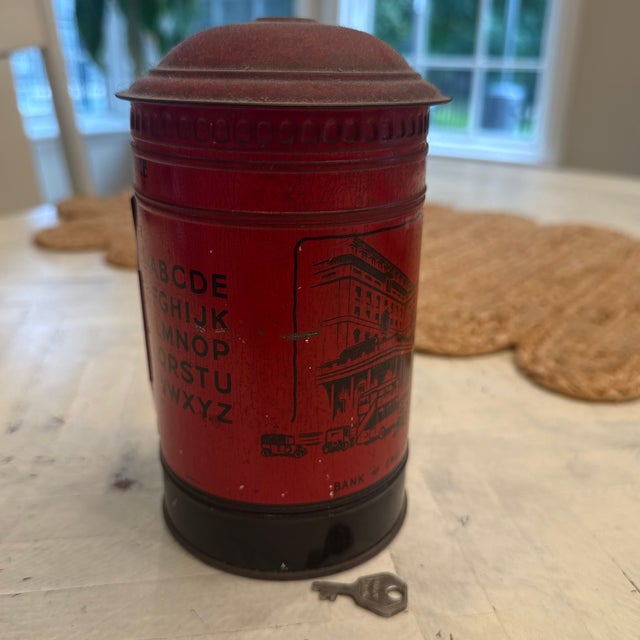Vintage Burnett Ltd. red tinplate post box money bank. Produced by Burnett Limited of London, a British toy company known...
