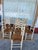 Italian Hand-painted set of ten dining chairs has a cream-colored wood frame with gold-toned accents. Each chair features...