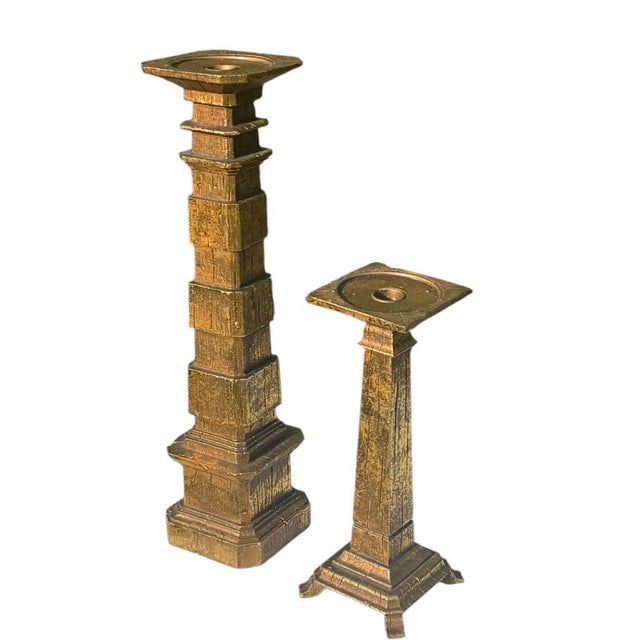 A striking pair of vintage sculptural candleholders featuring graduated architectural forms with a richly textured faux...