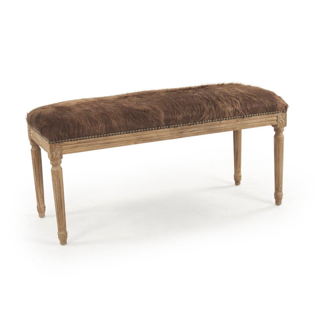 This is a bench featuring a sophisticated design with cowhide upholstery and an oak wood frame. The upholstery showcases a...