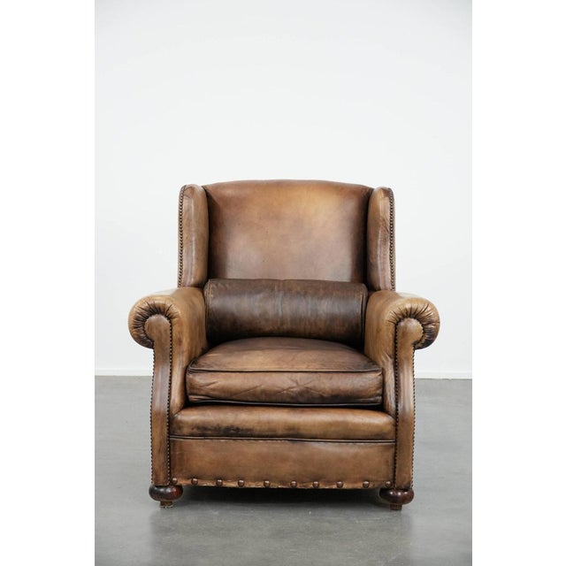 We are offering this luxurious, large, and well-maintained English-style cowhide wing chair in a beautiful color scheme....