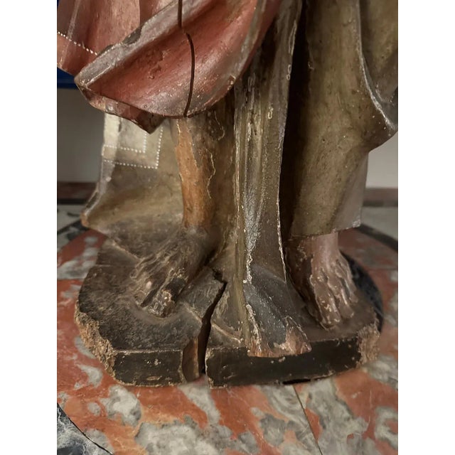 Hand-carved and painted, polychrome, Roman Santos figure in mid-stride. The figure wears stylized, flowing robes and...
