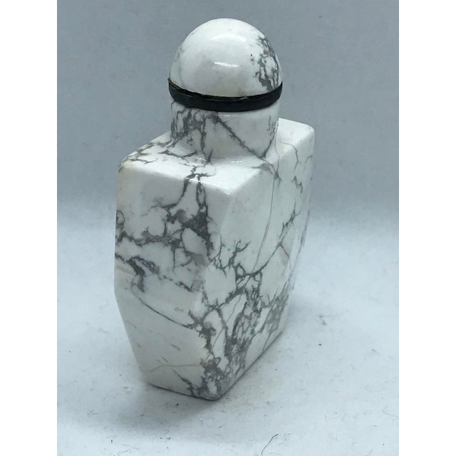 The stone is howlite, a calcium borosilicate hydroxide. It is naturally white with grey veins. The snuff bottle has a...