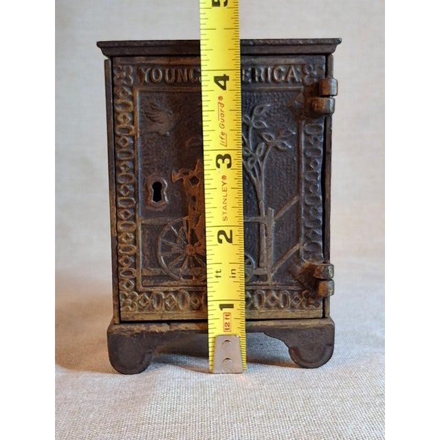 This is an authentic, highly collectible Late Victorian cast iron safe still bank, universally recognized by collectors as...