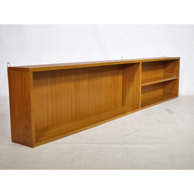 Minimalist mid-century wall shelf made of teak, 1960s. Long, low-profile design with a large open compartment on the left...