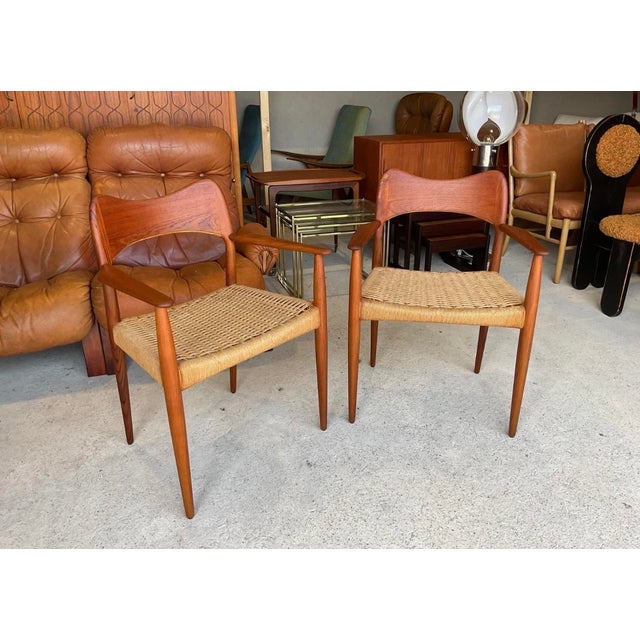 A set of 2 Danish teak and paper cord dining chairs designed by Arne Hovmand Olsen for Mogens Kold dating to the 1960s....