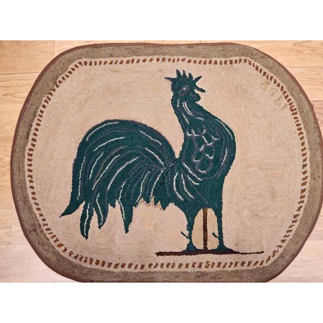 This vintage American hand-hooked rug features a striking pictorial depiction of a proud rooster standing tall and...