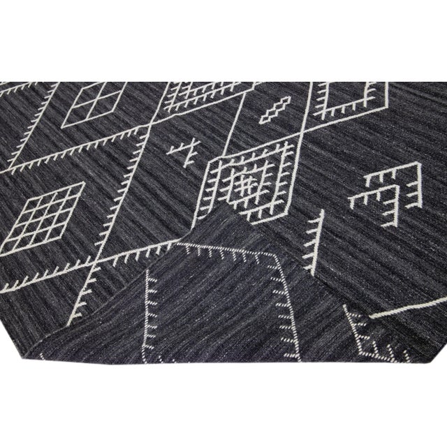 Beautiful kilim handmade wool rug with a grey-charcoal field. This custom modern flatweave rug of our Nantucket collection...