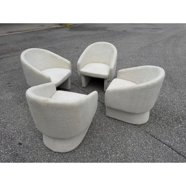 Set of four Noah Armchairs by Lievo, featuring sculptural curved silhouettes upholstered in textured cream bouclé. Each...