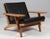 Hans j. Wegner lounge chair with loose cushions new upholstered with black full grain aniline leather. Frame of oak. With...