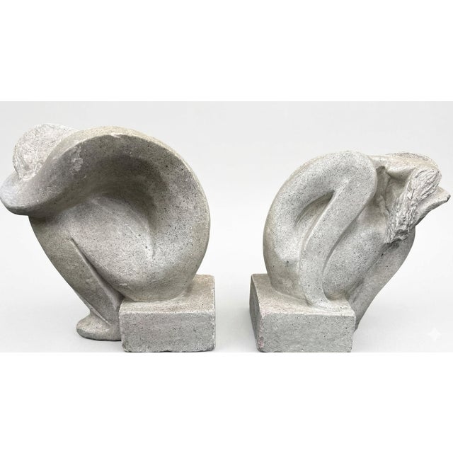 A sculptural pair of abstract nude female bookends by Austin Productions, each depicting a crouching female figure...