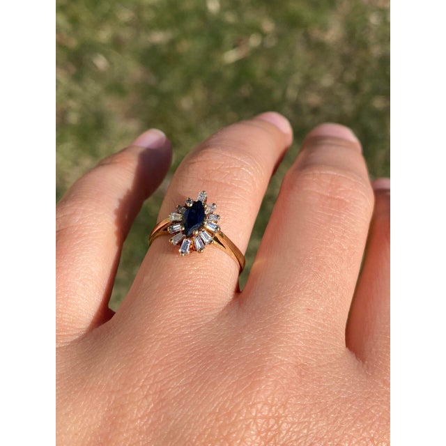 The Parksville: Vintage Sapphire and Natural Diamond Navette Ring in Yellow Gold. This stunning ring features a...
