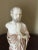 A statue of Hippocrates handmade in alabaster. It is white with intricate light brown shades for detail. It is skillfully...