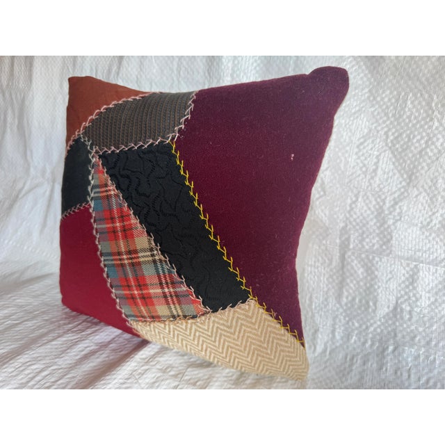 This vintage American patchwork pillow is hand-stitched from a variety of repurposed fabrics, showcasing traditional...