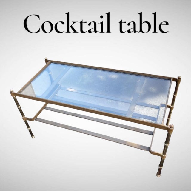 This table exemplifies Jacques Adnet's signature style, characterized by the combination of metal and saddle leather....