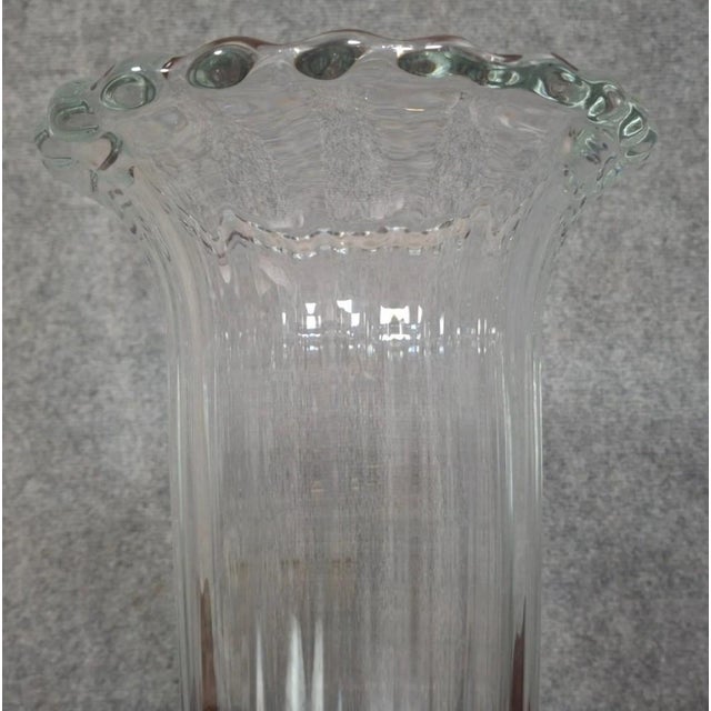 Large crystal vase signed Daum France, decorated with fine vertical ribs extending to an elegant, undulating, and...