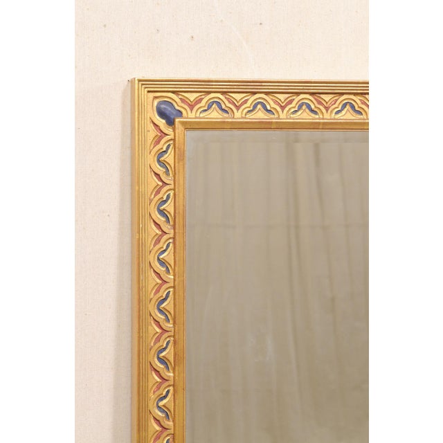 An impressive pair of large-sized vintage American wall mirrors with finely crafted giltwood frames with colorful hand-...