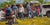 Waiting for the Train by Clyde Steadman | Oil Painting of people gathered by vehicles in a field For Sale