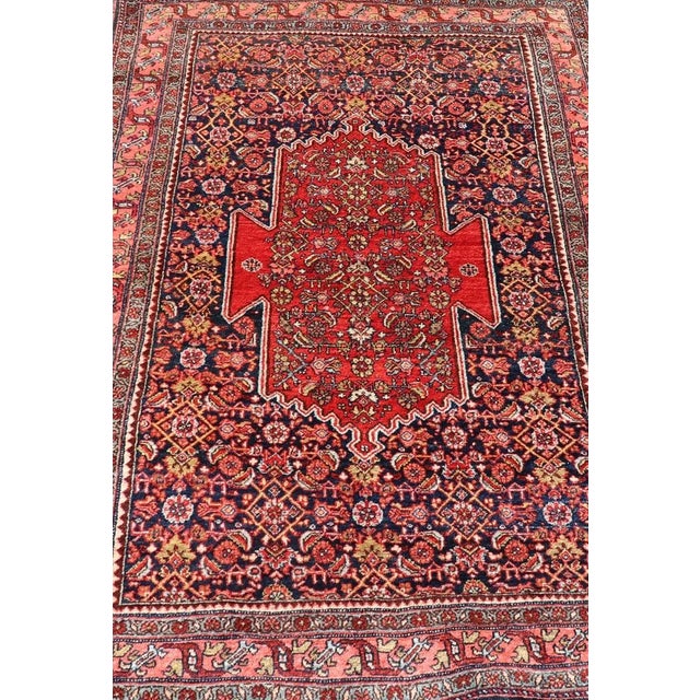 Measures: 4'5 x 6'7 The rug has a central medallion, surrounded by an intricate floral Herati design. The border utilizes...