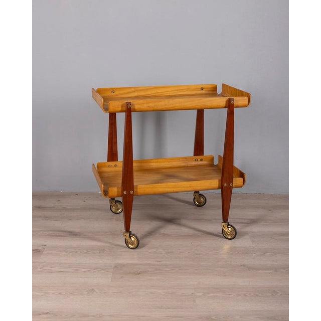 Food trolley with wooden frame and gilded brass inserts, with two shelves with curved ends, designed by Carlo Ratti,...
