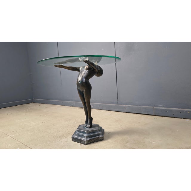 Vintage art deco style side bronze look table made of a resin base and a beveled glass clear top. Art deco style female...