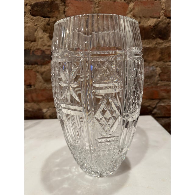 Impressive Waterford cut crystal tapered vase featuring deep vertical fluting at the rim, paneled sides with starburst and...