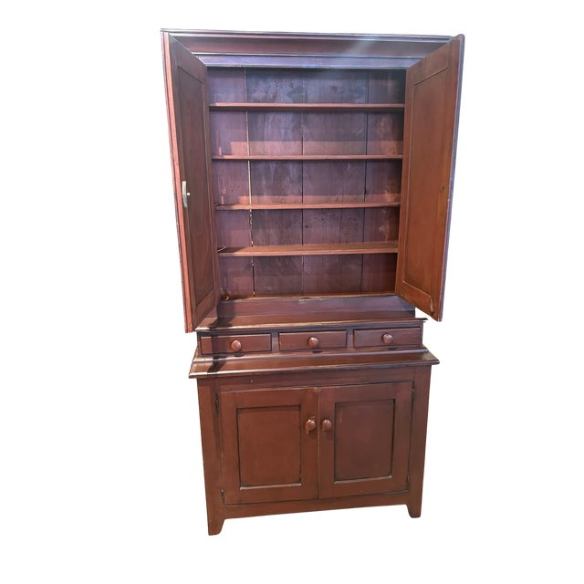 19th century step back cupboard. 2 panel door over 3 small drawers on 2 door base. Has been repainted a brick red....