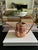 A vintage copper watering can with an elongated curved spout, arched handle and richly mottled aged surface. The...