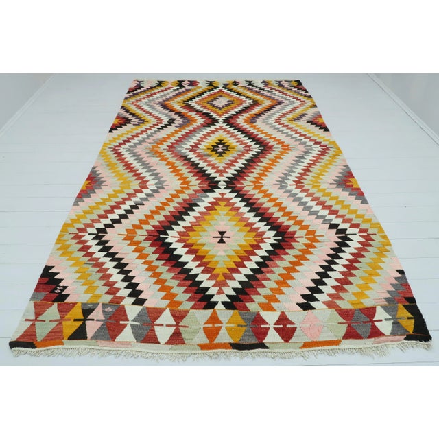 This Turkish Kilim rug hosts an intriguing pallet of vibrant rich and pastel colourways complementing a very Turkish sense...