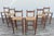 Beautiful vintage set of six Danish Modern style bar stools, circa 1970s, featuring solid wood frames with warm natural...