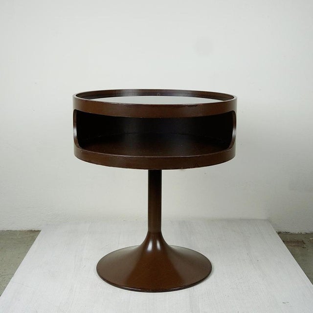This charming chocolate brown lacquered circular Space Age side table with metal tulip base and glass top has been...