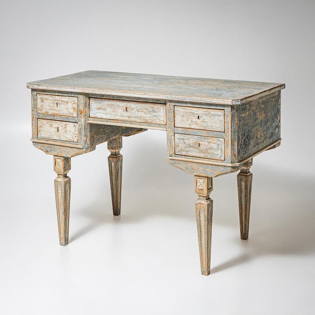 Desk with a straight top, five drawers and slender tapering legs. The desk offers practical storage. The blue-grey painted...
