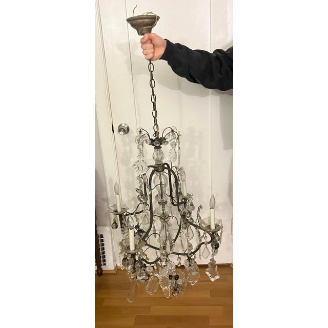 This is an antique French style chandelier featuring a dark bronze frame and numerous crystal drops. The design resembles...