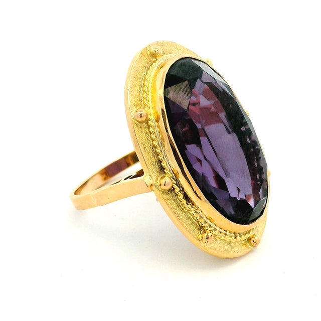 A striking vintage Italian cocktail ring featuring an oversized oval-cut amethyst weighing approximately 20 carats, set in...