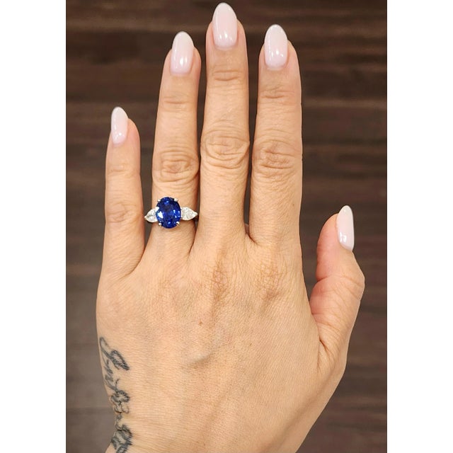 This exquisite cocktail ring features a captivating 5.42-carat oval blue sapphire as its centerpiece, set in luxurious...