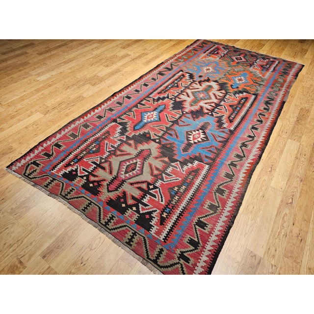 This early 20th-century Caucasian Kazak kilim from the Shirvan region of the Southern Caucasus is a vibrant example of...